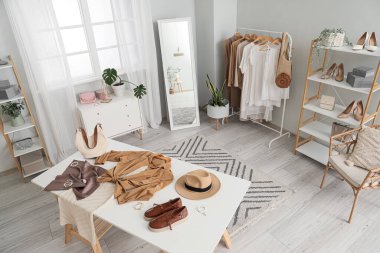 Giysi tasarımcısının stüdyosunun içinde iş yeri ve ayna var.