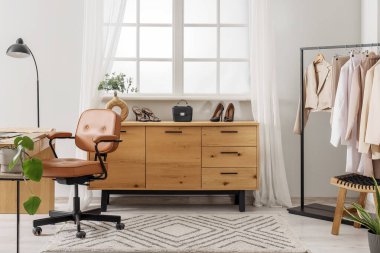 Çalışma yeri, askısı ve tuvaleti olan kıyafet tasarımcısının stüdyosu.