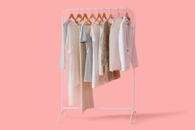 Pembe arka planda şık kıyafetler.