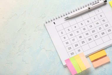 Renk arkaplanı üzerinde kalem ve yapışkan notlara sahip takvim. Planlama kavramı