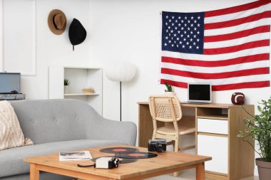 ABD bayrağı, kanepesi ve işyeri olan oturma odasının içinde.