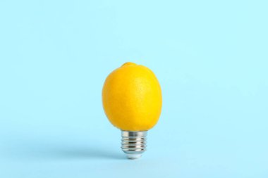 Mavi arka planda limonlu ampul. Yeşil teknoloji kavramı