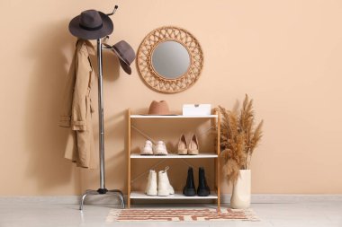 Koridorun içinde şık şapkalar, palto askısı ve raf ünitesi var.