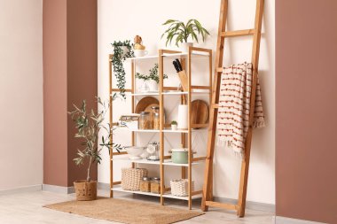 Ahşap raf ünitesi, merdiven ve bitkilerle birlikte mutfağın içinde.