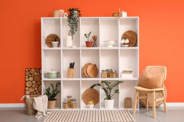 Mutfağın içinde raf ünitesi, sandalye ve bitkiler.