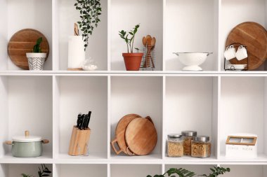 Mutfak gereçleri beyaz raflarda bitkiler