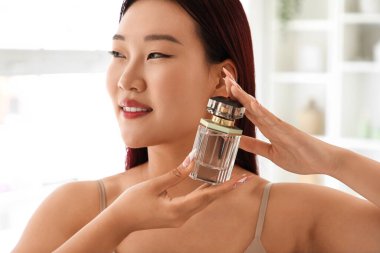 Banyoda parfümlü genç Asyalı kadın, yakın plan.