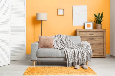 Beyaz perdeli, kanepeli ve lambalı oturma odasının içinde.