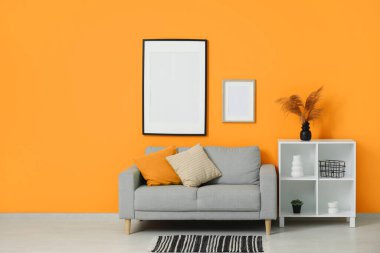 Oturma odasının iç tarafında rahat bir kanepe ve raf var.