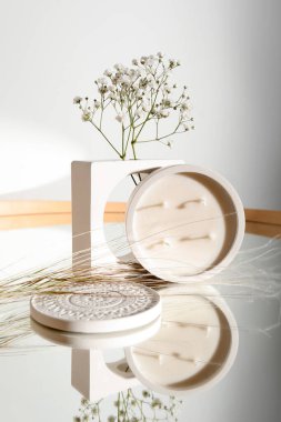 Odadaki aynada çingene çiçekleri ve mum, yakın plan.