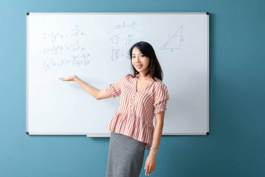 Sınıfta yazı tahtasının yanında Asya Matematik öğretmeni