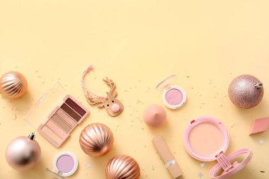 Dekoratif kozmetik ürünleri ve bej arka planda Noel dekoru olan kompozisyon