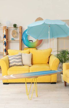 Sörf tahtası ve plaj aksesuarları olan şık bir oturma odası.