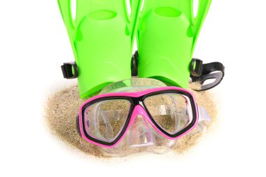 Yeni yüzme maskesi, kum yığını ve beyaz arka planda paletler.