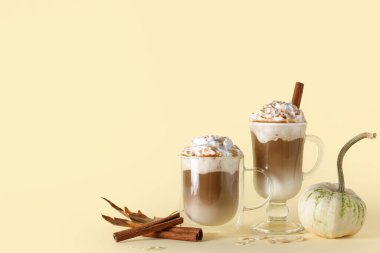 Sarı arka planda tarçınlı ve bademli balkabaklı latte.