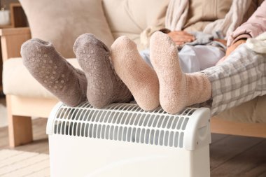 Genç çift kaloriferde ısınıyor, yakın plan.