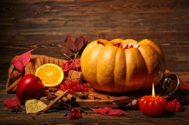 Ahşap arka planda balkabağında lezzetli sıcak şarapla güzel bir kompozisyon.