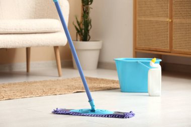 Oturma odasında paspasla ahşap kaplama zemin temizleme, yakın plan.