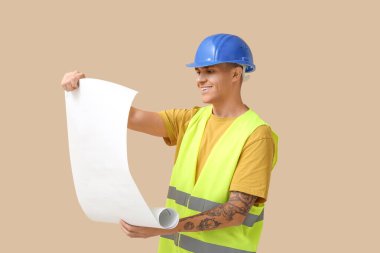 Bej arka planı olan genç bir erkek mühendis.