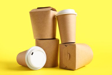Sarı arka planda paket kâğıt bardak ve kutular