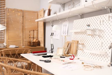 Atölyedeki kuyumcu masasında aletleri olan şık aksesuarların çizimleri.