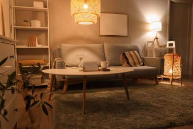 Gri kanepesi, sehpası ve gece lambasıyla modern oturma odasının içinde.