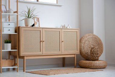 Ahşap çekmeceler, hasır puflar ve oturma odasının içindeki raf ünitesi.