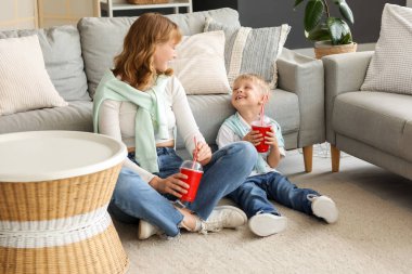 Mutlu anne ve küçük oğlu ellerinde bir bardak sodayla oturma odasında oturuyorlar.