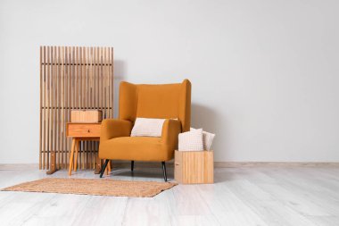 Kahverengi koltuklu, sehpalı, yastıklı ve katlanır perdeli bir oturma odası.