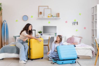 Yurt odasında bavulları olan kız öğrenciler taşındıkları gün