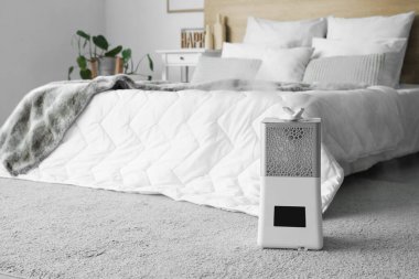 Halıdaki modern hava nemlendirici açık yatak odasında.