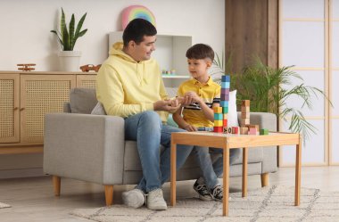 Baba ve küçük oğlu evde küplerle oynuyorlar.