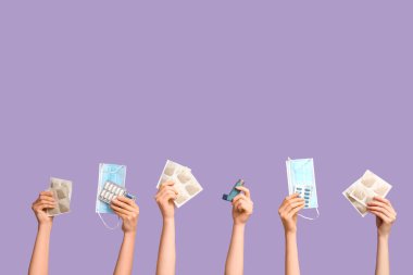 Hardal alçılı kadın elleri, astım spreyi, tıbbi maskeler ve mor arka planda haplar.