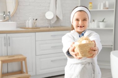 Banyoda sabun barları olan sevimli küçük bir kız.