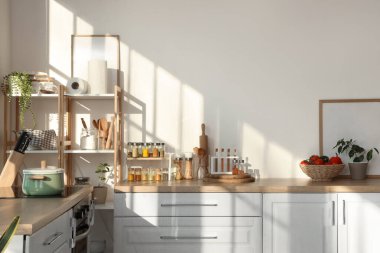 Mutfaktaki tezgahlarda farklı baharat, yemek ve çatal bıçak bulunan kavanozlar.