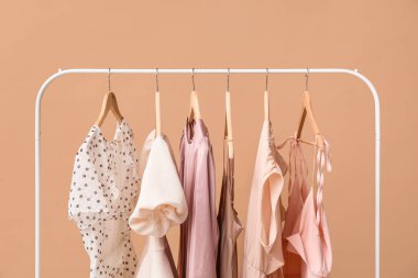 Askıda asılı güzel kadın elbiseleri Renk duvarına, yakın plan