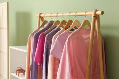 Odadaki yeşil duvarın yanında kadın giysileriyle doldur.