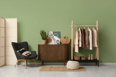 Elbise askısı, klozet ve koltuğu olan soyunma odasının içinde.