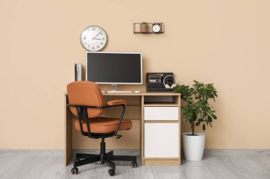 Masası ve kahverengi sandalyesi olan bir ofis.