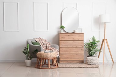 Oturma odasının içinde koltuk, ayna ve tuvalet var.