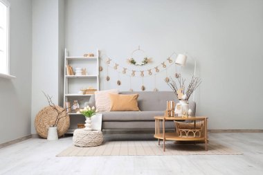 İçinde kanepe, raf ve sehpanın üstünde Paskalya süslemeleri olan şenlikli bir oturma odası.