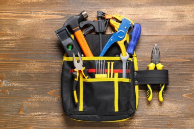 Ahşap arka planda inşaat aletleri olan çanta