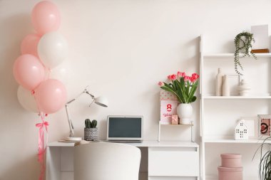 Kadınlar Günü için işyeri, raf ünitesi ve balonlarla dekore edilmiş ofis.