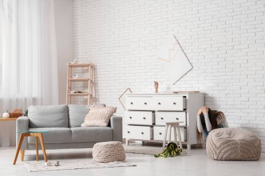 Deprem sırasında oturma odasında göğsünün yanındaki çekmeceleri kapatan korkmuş genç kadın.