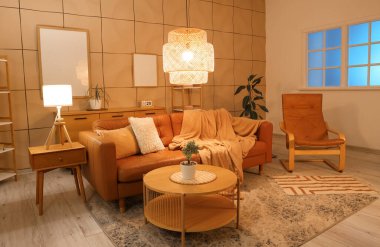 Kahverengi kanepesi, sehpası ve akşam lambaları olan şık bir oturma odası.