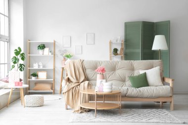 Anneler Günü için dekore edilmiş oturma odasının içi kanepe, masa ve raf üniteleriyle dolu.