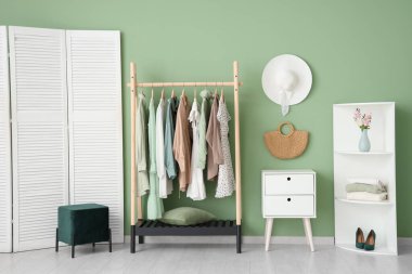 Giysi askısı, katlama perdesi ve raf ünitesi olan şık bir soyunma odası.