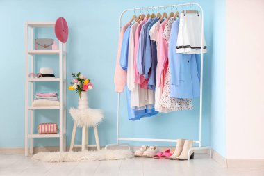 Renk duvarına karşı şık kadın kıyafetleri, bahar çiçekleri ve aksesuarları dizin.