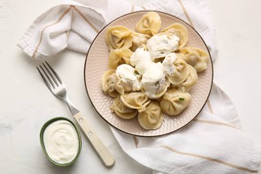 Beyaz arka planda ekşi kremalı lezzetli kaynamış hamur köfteleri.