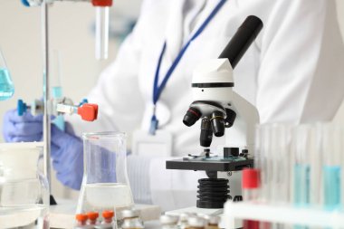 Laboratuvarda çalışan kadın bilim adamına karşı mikroskop, yakın plan.